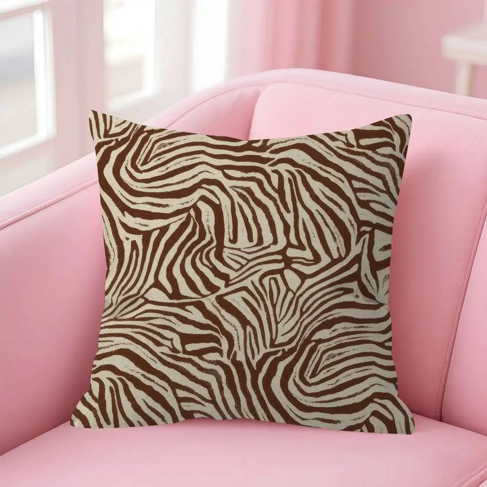 A decorative pillow cover with a brown and beige leopard print pattern resting on a pink sofa.