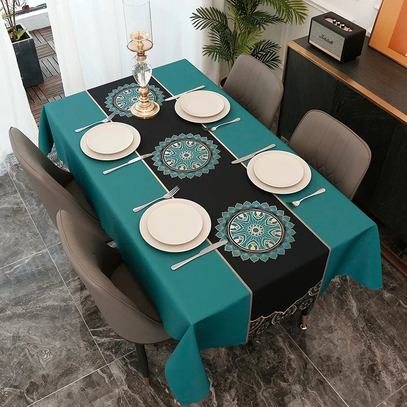 A rectangular teal tablecloth set for dining or party decor featuring black and teal accents and decorative plates.