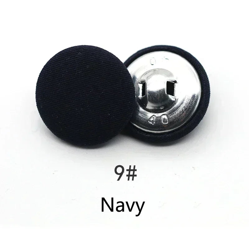 A single black fabric-covered shank button with a silver back is shown against a white background.