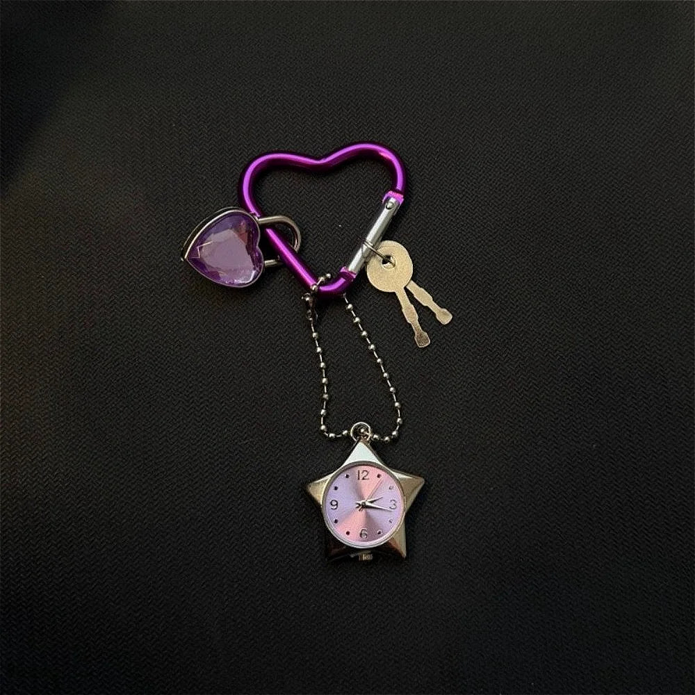 A purple heart-shaped keychain featuring a pink and silver star pocket watch.