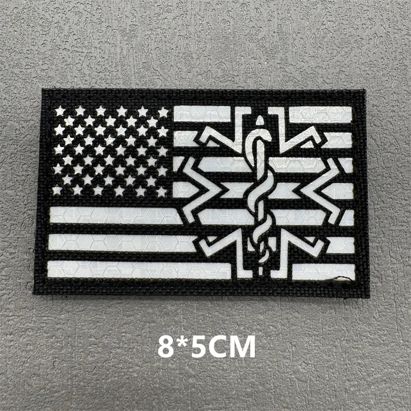 Black embroidered patch featuring a white American flag design on a gray background.