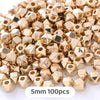 A pile of gold-colored geometric acrylic beads, 5mm size, for jewelry making.