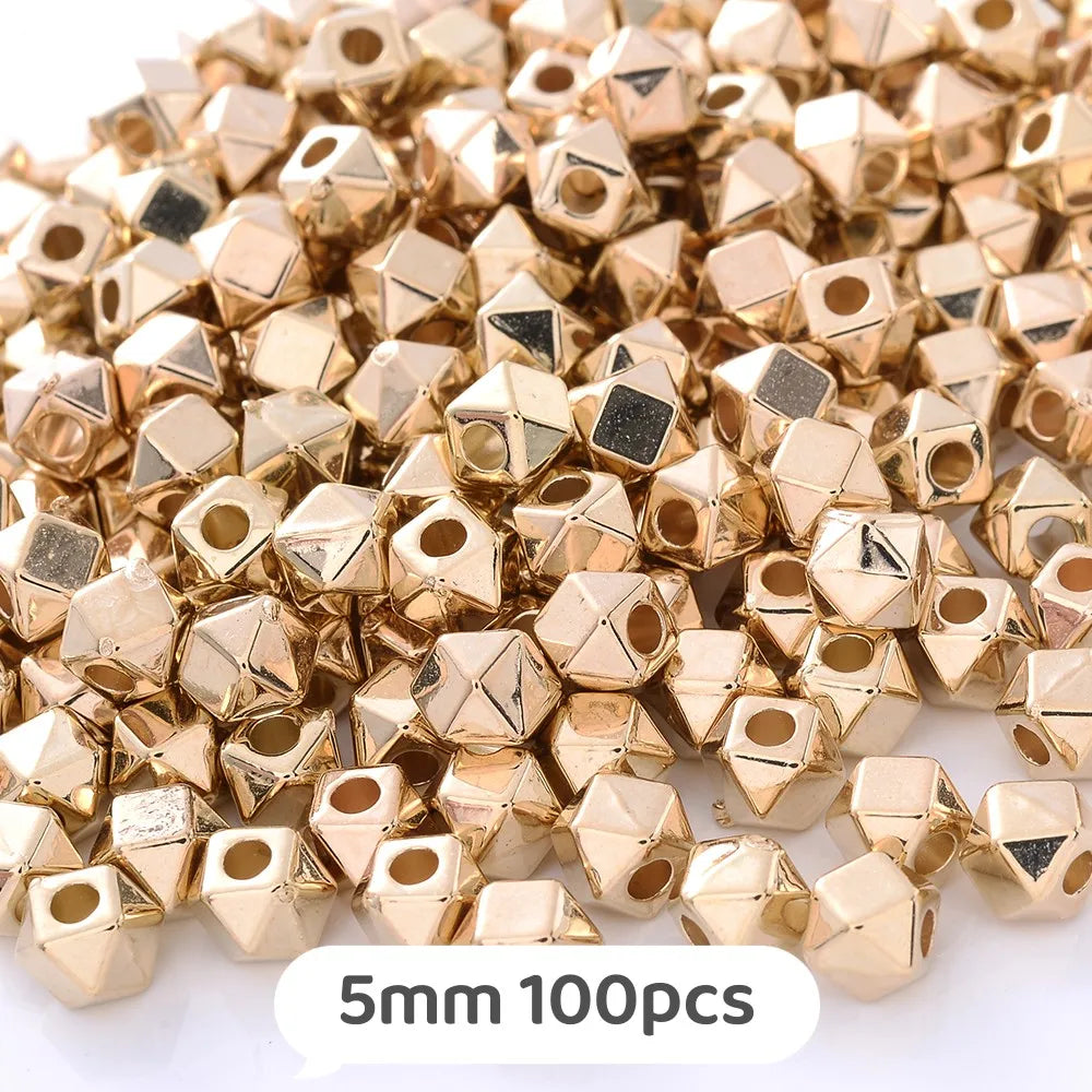 A pile of gold-colored geometric acrylic beads, 5mm size, for jewelry making.