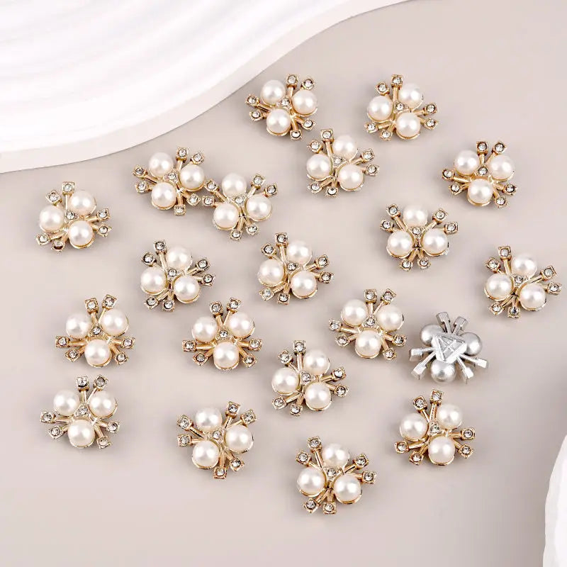 A set of flower-shaped resin button rhinestones in off-white and silver tones.