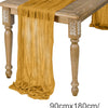 A golden brown semi-sheer gauze table runner draped over a wooden table.