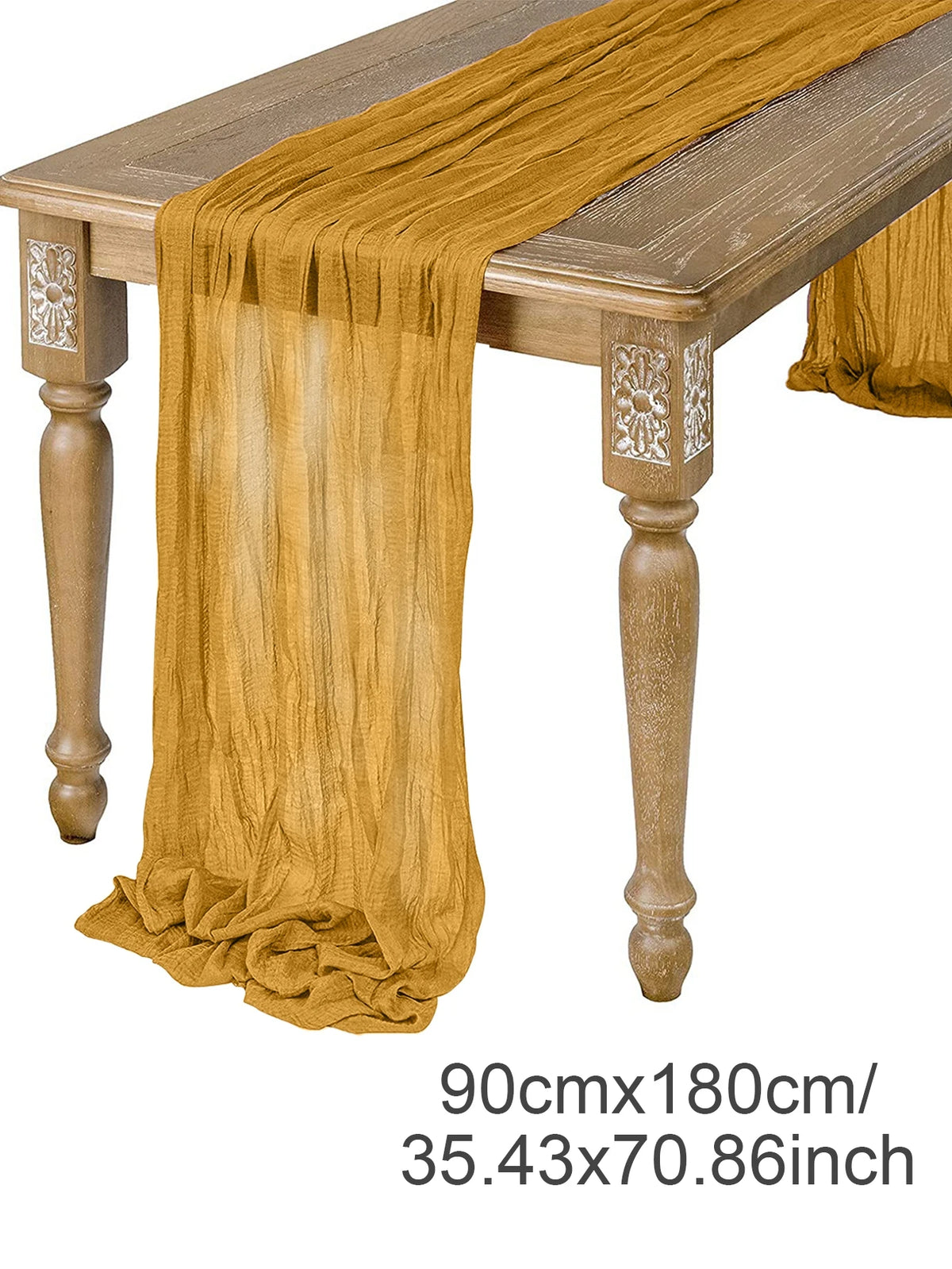 A golden brown semi-sheer gauze table runner draped over a wooden table.
