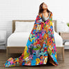 A woman is lying on a bed with a colorful flannel throw blanket featuring Sesame Street characters.