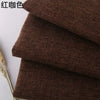 Stack of dark brown coarse linen or cotton fabric rolls