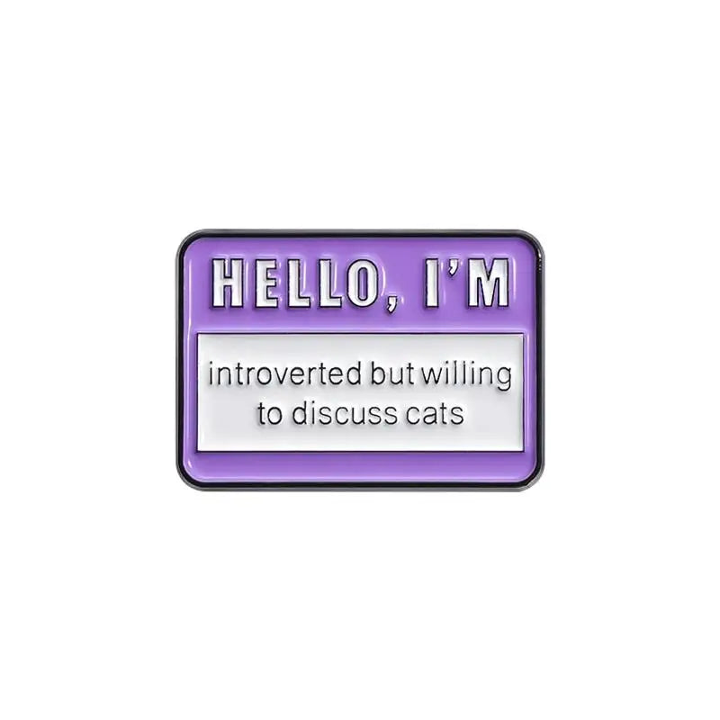 A lapel pin featuring the text HELLO, I'M introverted but willing to discuss cats on a purple background.