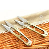 A pair of gold-toned U-shape sewing scissors resting on a woven straw mat.