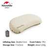 A beige inflatable camping pillow with a storage bag shown next to it.