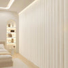 A vertical pleated white fabric room divider curtain in a modern, bright interior setting.