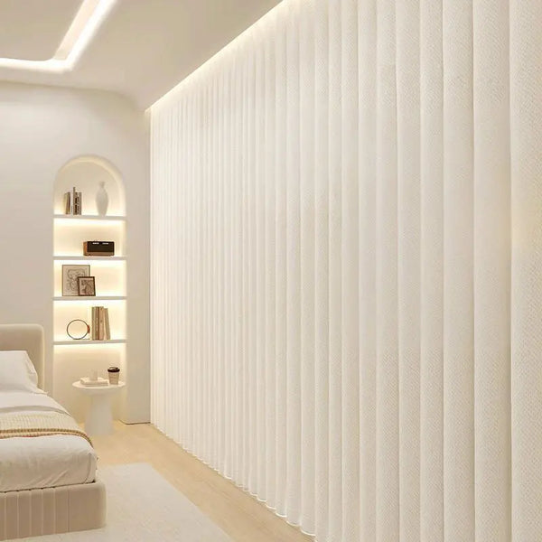 A vertical pleated white fabric room divider curtain in a modern, bright interior setting.