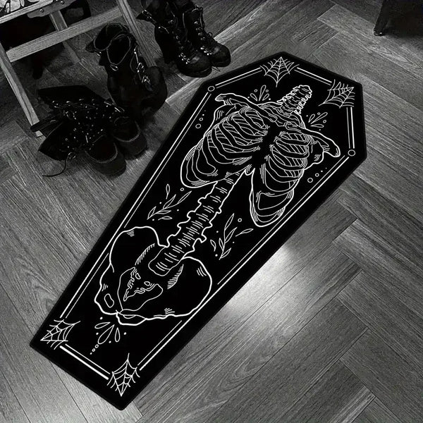 A black carpet featuring a white print of a coffin-shaped skeleton and spider design.