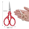 Pair of red and white embroidery scissors shown next to a hand for scale