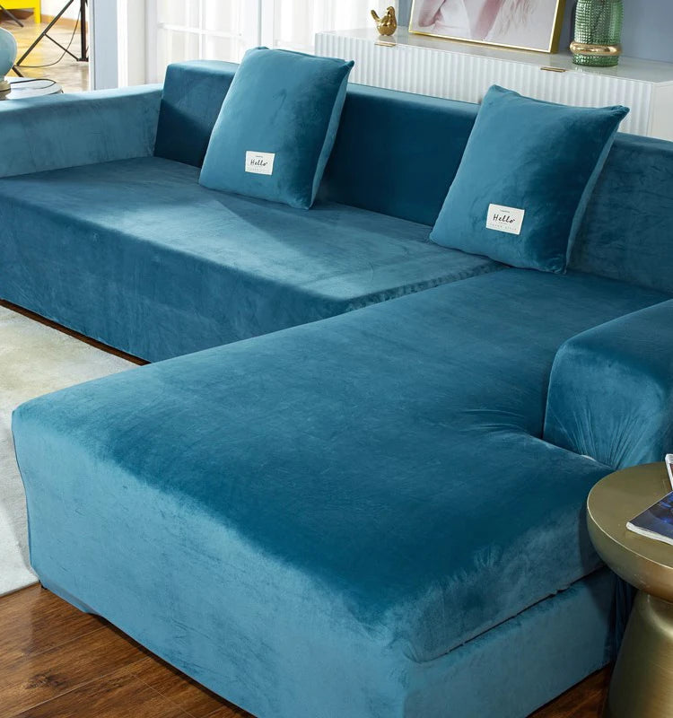 A deep teal velvet sofa cover for an L-shaped sectional with matching throw pillows.