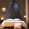 A dark blue dome mosquito net draped over a bed, creating a private sleeping area.