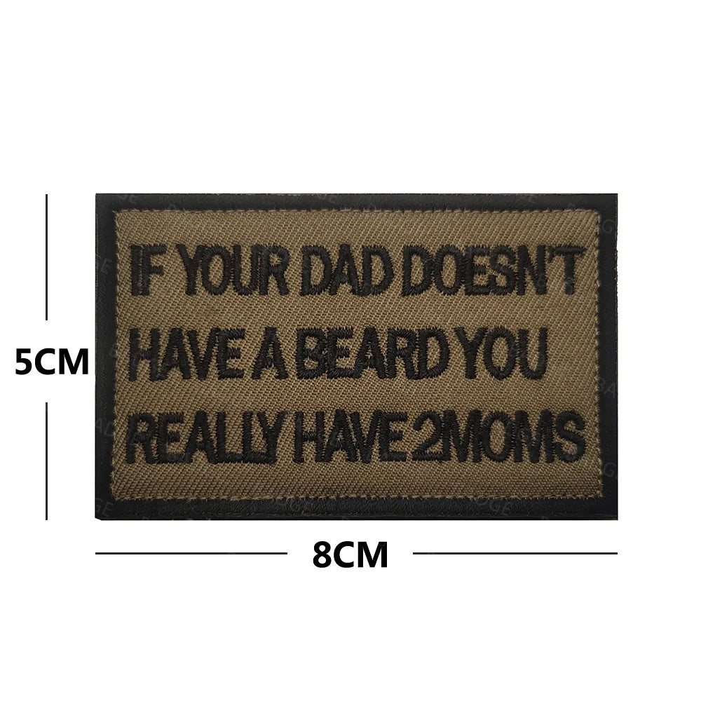A rectangular black embroidered patch with white text that reads If your dad doesn't have a beard you really have 2 moms