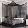 A large four-door mosquito net draped over a bed frame in a bedroom setting.