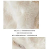 Close-up of a light beige faux fur fabric showing the texture and stitching detail.