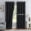 A set of two black blackout grommet curtains hanging in a window frame.