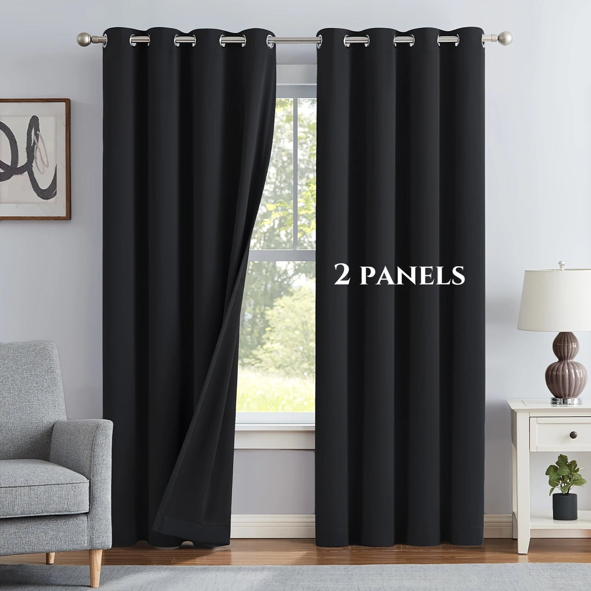 A set of two black blackout grommet curtains hanging in a window frame.