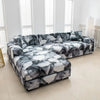 A modern gray and white floral patterned sofa protector cover displayed on a light wood floor.