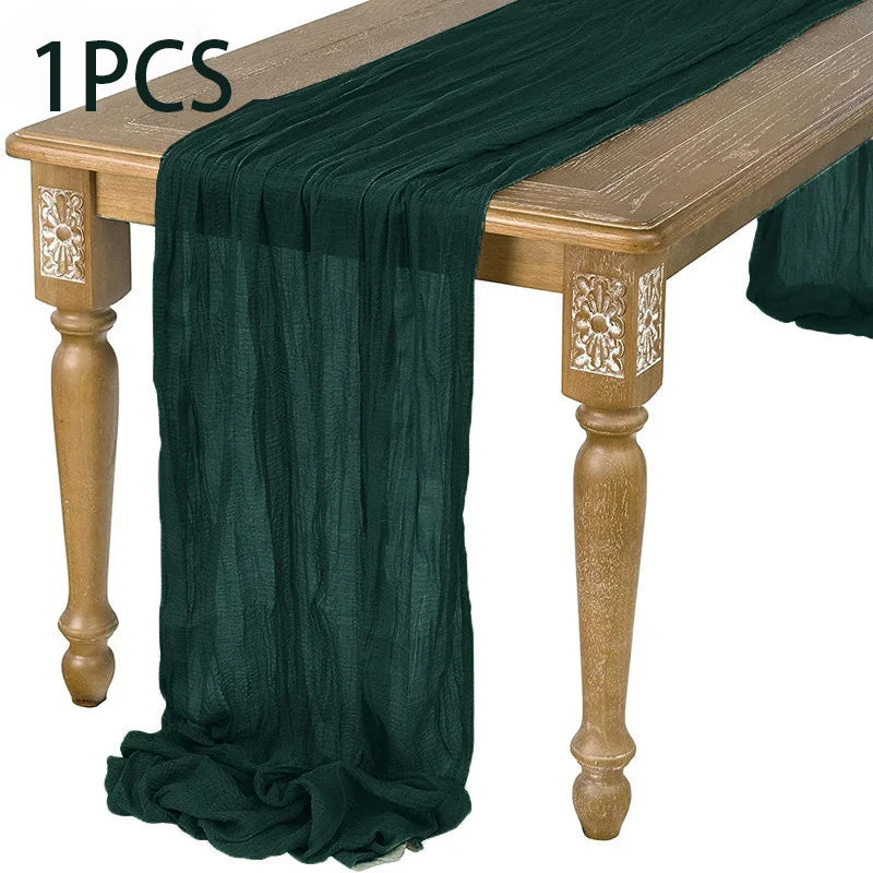 A dark green semi-sheer gauze fabric draped over a wooden table.