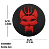 A red rubber embroidered patch featuring a stylized skull and crossbones design on a black background.