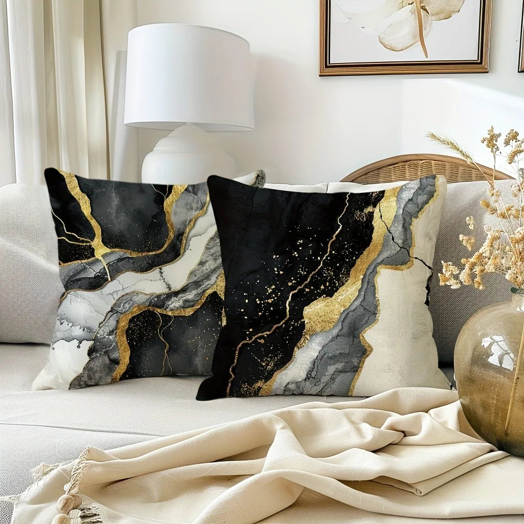 A black and gold marble print decorative pillow cover resting on a light-colored sofa.