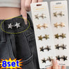 A set of eight adjustable metal star brooch pins displayed on a white card against a dark denim background.