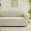 A beige sofa slipcover featuring a woven jacquard leaves pattern in a light neutral tone.