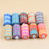 A collection of ten spools of brightly colored rainbow sewing thread arranged in a row.