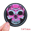 Embroidered skull iron-on patch featuring pink and blue hues on a black background