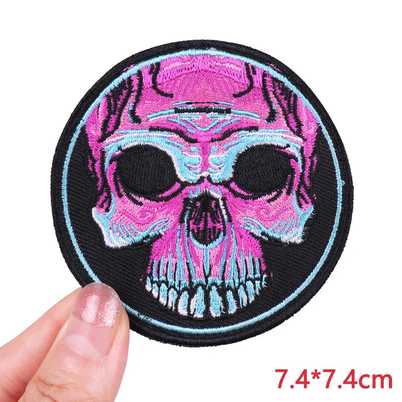 Embroidered skull iron-on patch featuring pink and blue hues on a black background