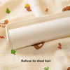 A white baby grooming tool is shown resting on a light-colored fabric with small animal print.