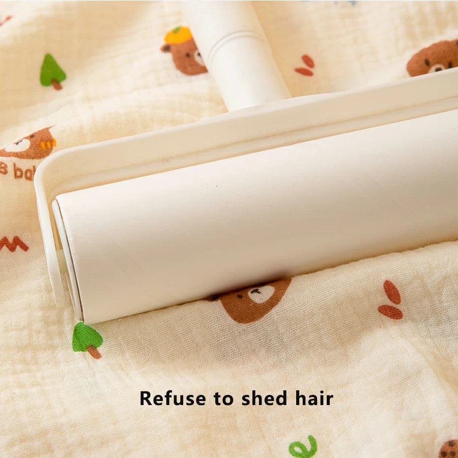 A white baby grooming tool is shown resting on a light-colored fabric with small animal print.