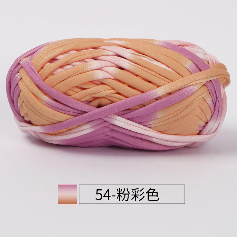 A ball of hand-dyed fabric strip yarn in shades of peach and lavender for crochet and knitting.