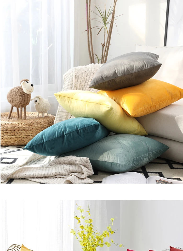 A collection of various colored velvet cushions, including gray, yellow, and teal, displayed on a light-colored sofa.