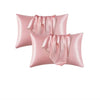 Two pink satin silk pillow covers with draped fabric