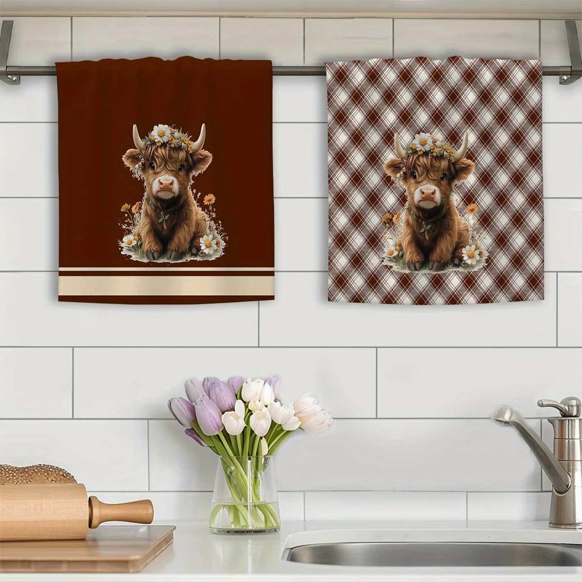 A set of two absorbent plaid kitchen towels featuring adorable baby goats.
