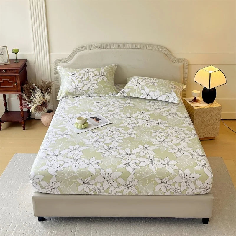 A light green floral printed cotton fitted sheet for a queen or king bed with a upholstered headboard.