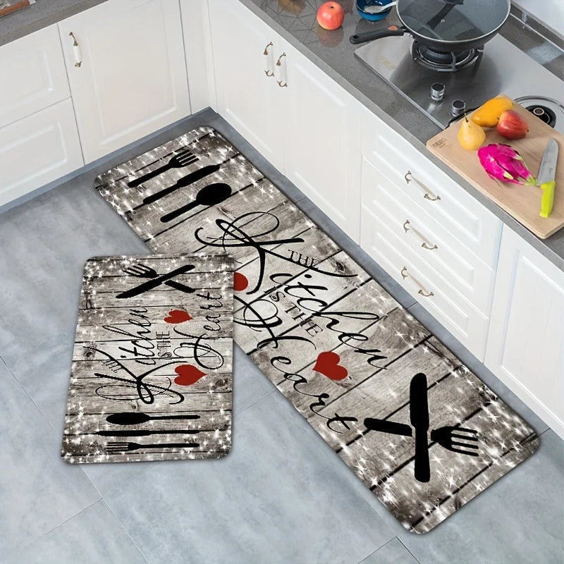 A rectangular kitchen mat featuring a heart design with knife and fork graphics on a gray distressed background.