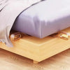 A mattress lifter wedge is shown under a bed, used for easy bedding changes.