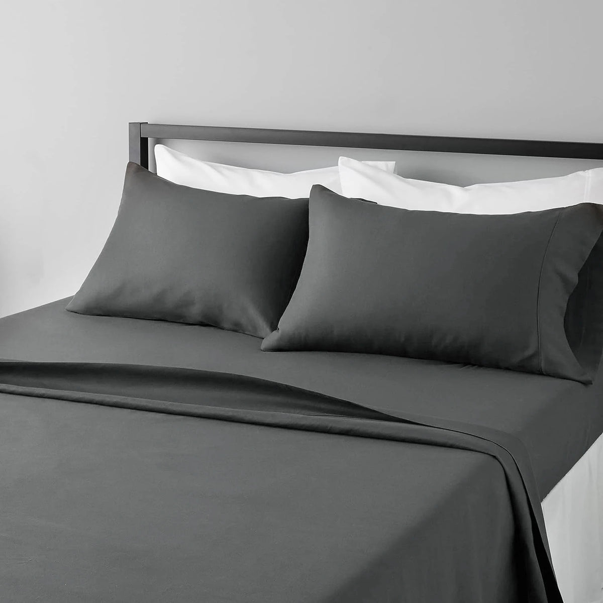 A dark gray microfiber flat fitted sheet set on a bed with white pillows and bedding.