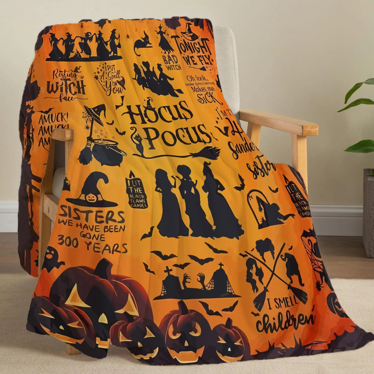 An orange and black Halloween-themed flannel throw blanket featuring witches, pumpkins, and spooky designs.