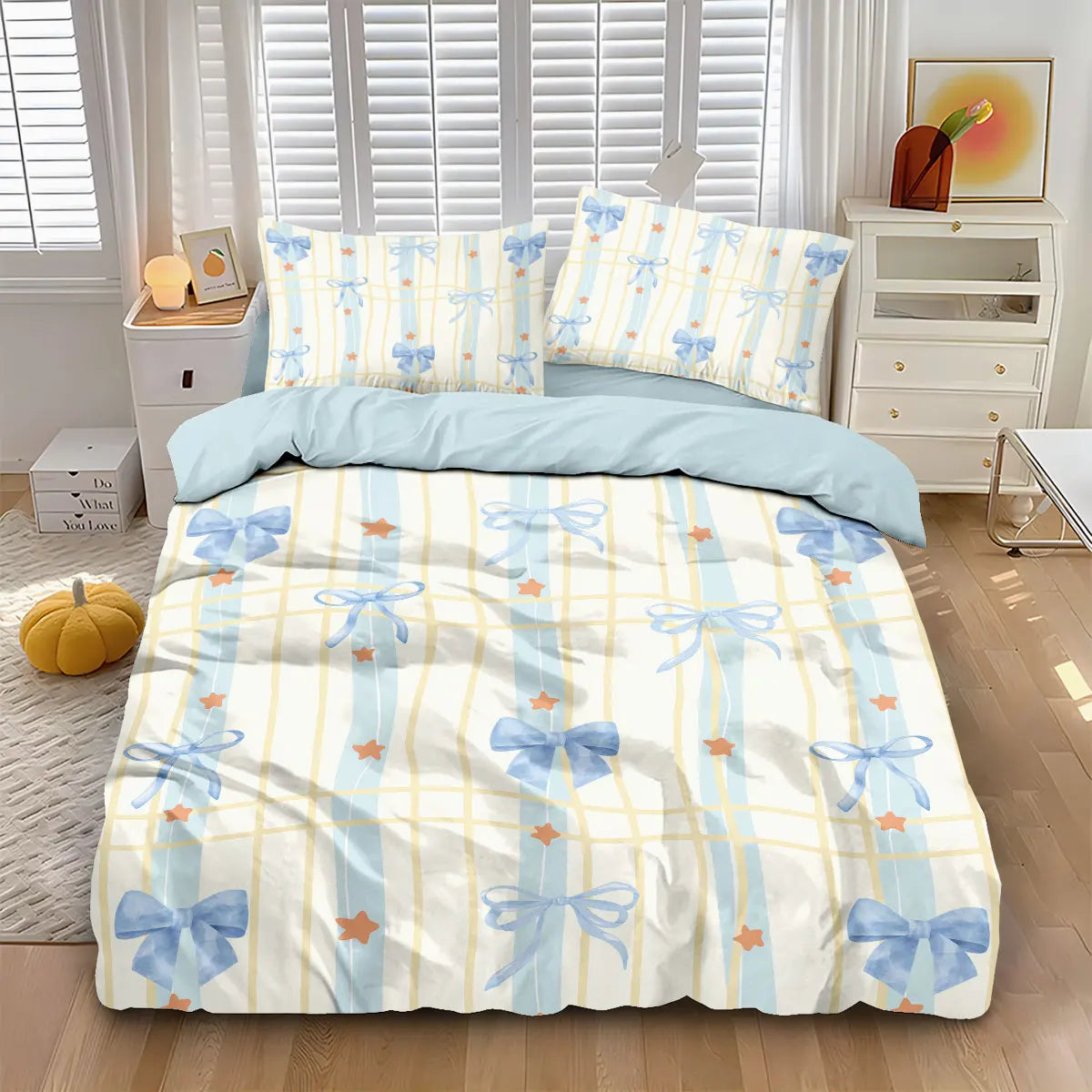 A set of three pink bow printed duvet covers featuring light blue and yellow stripes displayed on a bed.