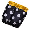 A black polka dot ruffle apron with yellow trim and pockets.