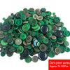 A pile of assorted dark green resin sewing buttons for crafting and DIY projects.