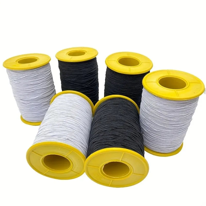 Rolls of white and black elastic sewing thread with yellow spools